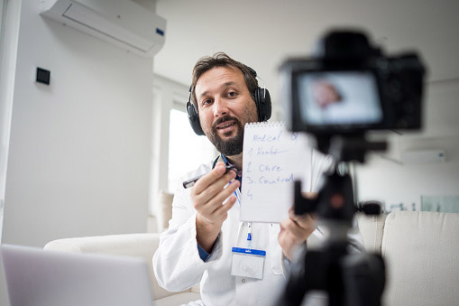 A doctor recording video using a professional camera