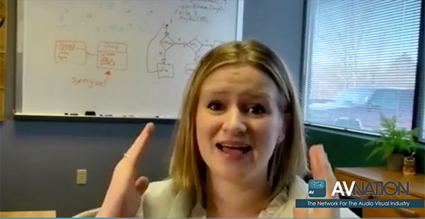 Professor teaching remotely over video in front of a laptop.