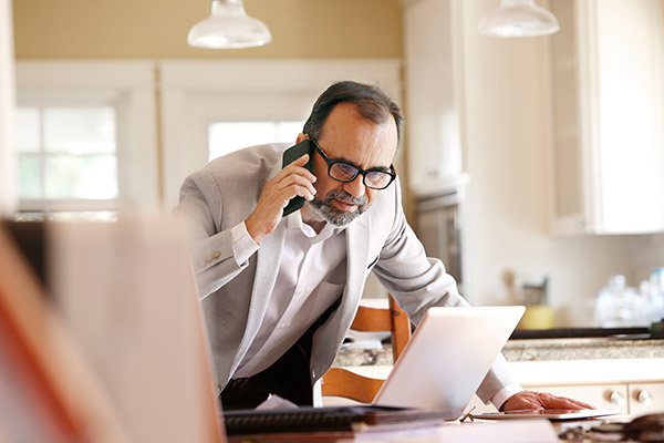Man in suit on phone and on computer.