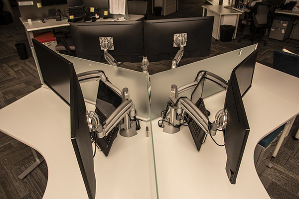 Monitor mounts around a desk shot from above.