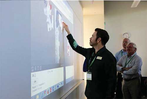 Attendees of the symposium use interactivity features of the IDEA Panoramic screens and Epson 595Wi short throw projectors to assemble puzzles