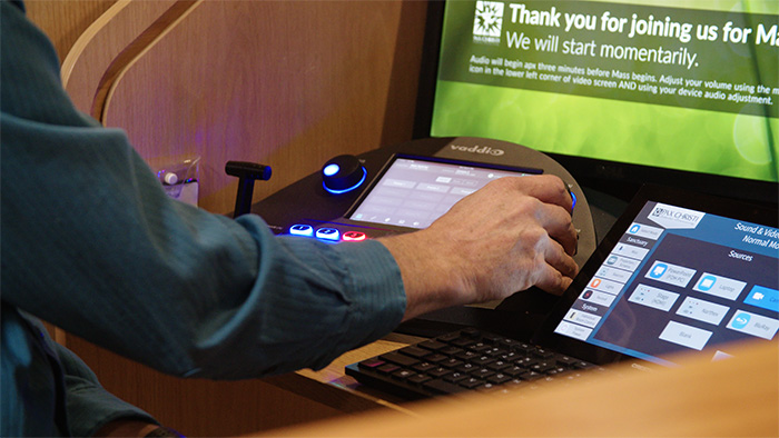 Close up on a hand using the Vaddio controller.