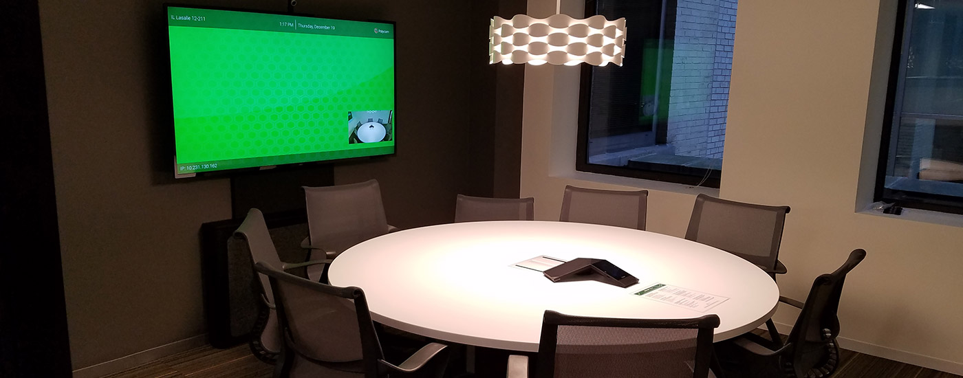 Conference room with round table and Tempo holding a display.