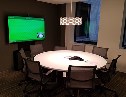 Conference room with round table and Tempo holding a display.