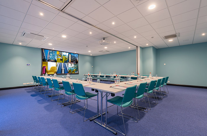 Small conference room with tables and projection screen.