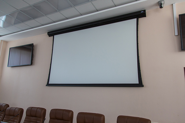 A Da-Lite screen on the wall in a lecture hall
