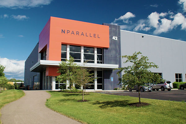 exterior of NPARALLEL office building with trees and blue sky