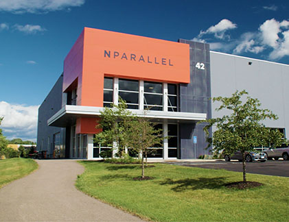 exterior of NPARALLEL office building with trees and blue sky