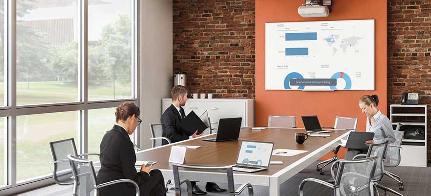 Conference room with a table, chairs and a Da-Lite interactive projector screen with Chief short throw projector mount with projector.