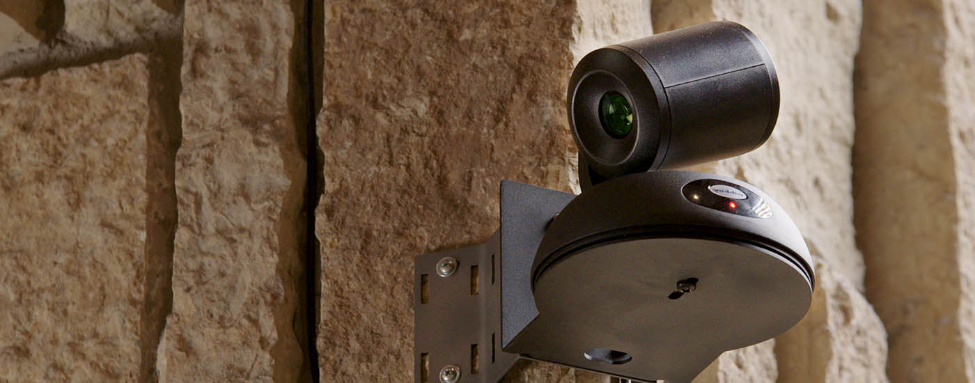 Vaddio RoboSHOT Elite NDI PTZ Camera mounted to stone wall